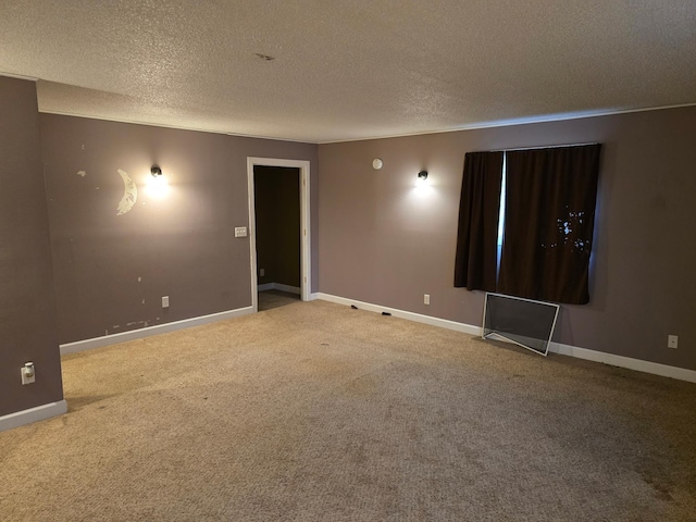 empty room featuring a textured ceiling and carpet flooring