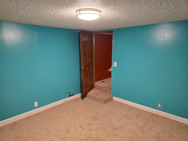 unfurnished room with a textured ceiling and carpet floors