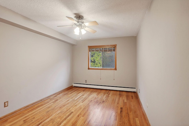 spare room with ceiling fan, a textured ceiling, a baseboard radiator, and light wood-type flooring