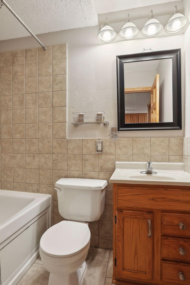 full bathroom with a textured ceiling, tile walls, toilet, vanity, and tile patterned flooring