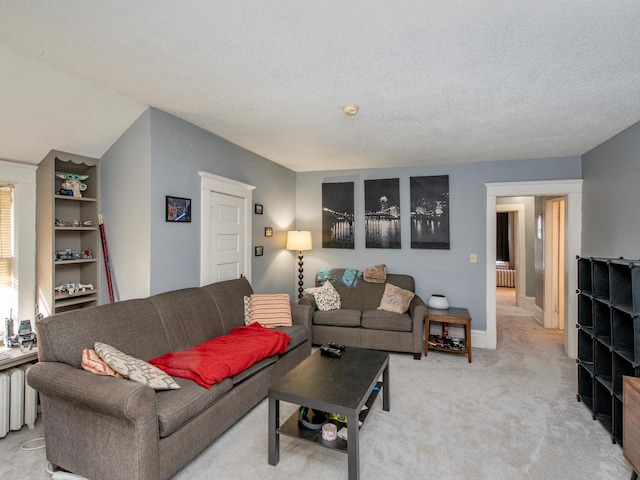 living area featuring light carpet, a textured ceiling, and baseboards