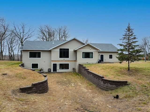 back of house featuring a lawn and central AC unit