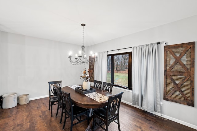 dining space featuring dark hardwood / wood-style flooring and a chandelier