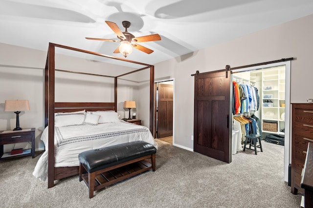 bedroom with ceiling fan, a barn door, and light colored carpet