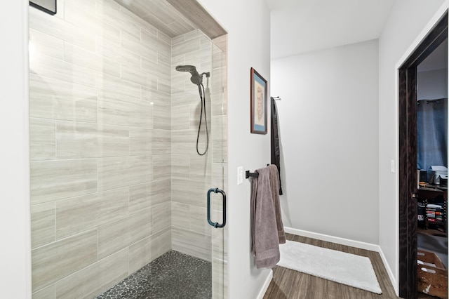 bathroom with hardwood / wood-style flooring and an enclosed shower