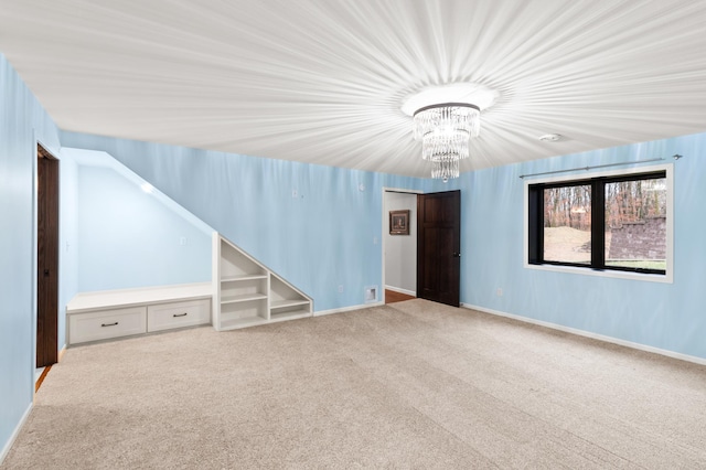 carpeted spare room featuring an inviting chandelier and lofted ceiling