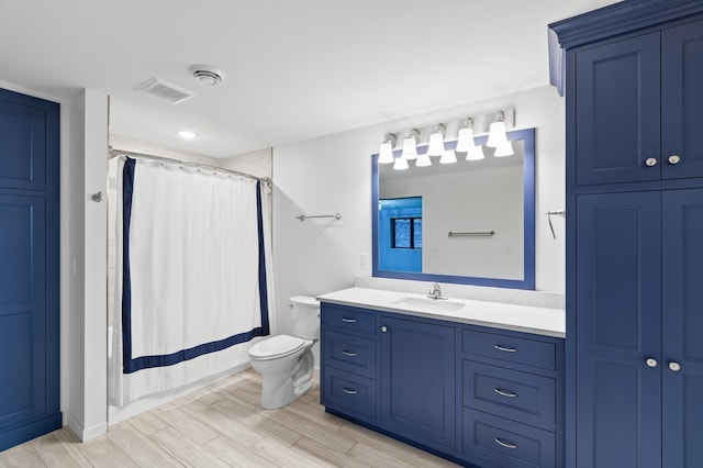 bathroom with hardwood / wood-style floors, vanity, toilet, and a shower with curtain