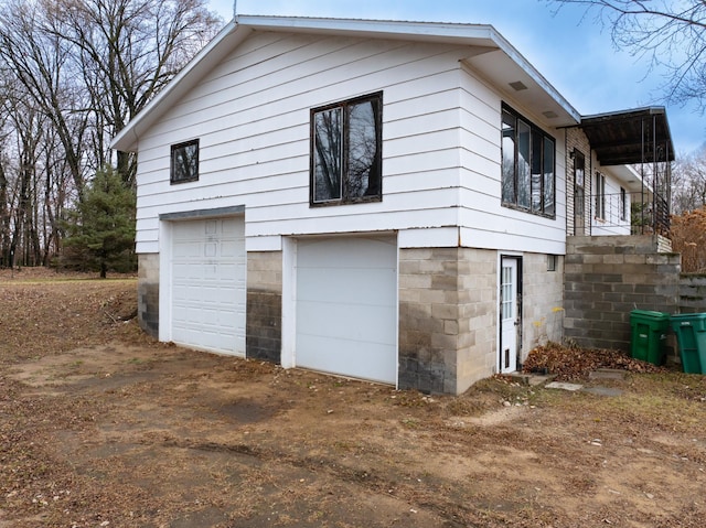 view of home's exterior featuring a garage and a balcony