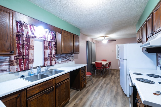 kitchen with ceiling fan, white electric range oven, tasteful backsplash, light hardwood / wood-style floors, and a textured ceiling