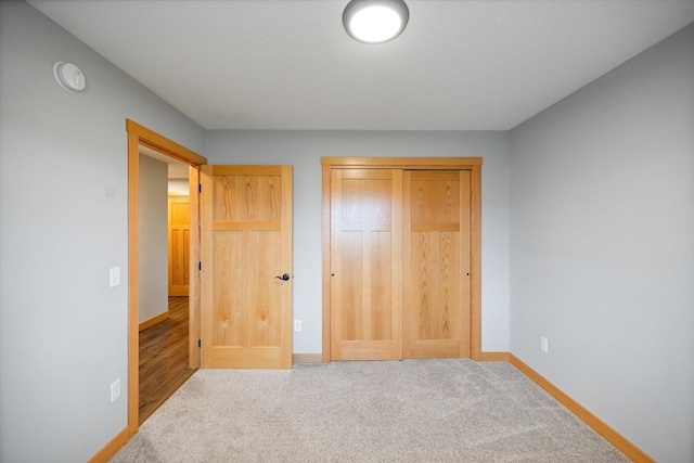 unfurnished bedroom featuring a closet and light carpet