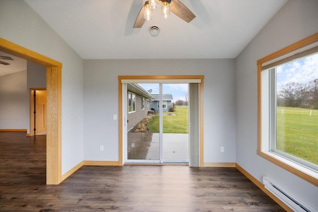 unfurnished room featuring baseboard heating, a wealth of natural light, and lofted ceiling