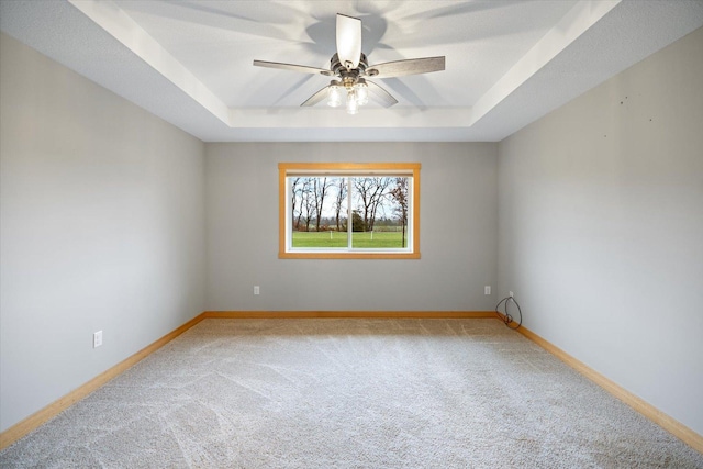 unfurnished room featuring ceiling fan, carpet, and a tray ceiling