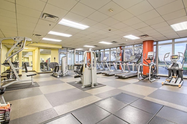 workout area with a drop ceiling and expansive windows