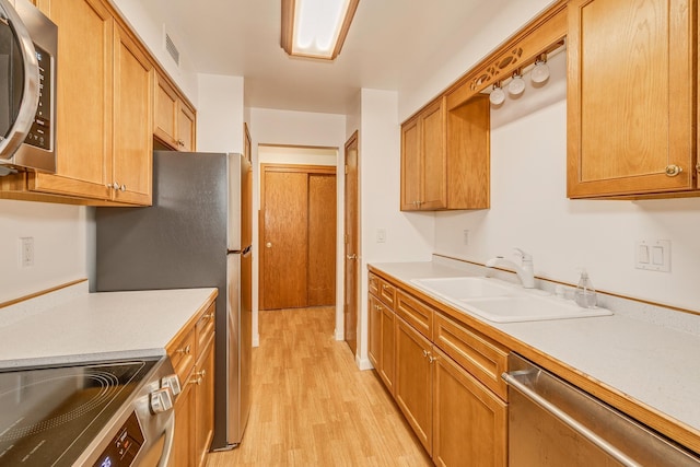 kitchen featuring stainless steel appliances, light hardwood / wood-style floors, and sink