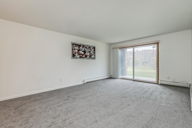 spare room with carpet flooring and a baseboard heating unit