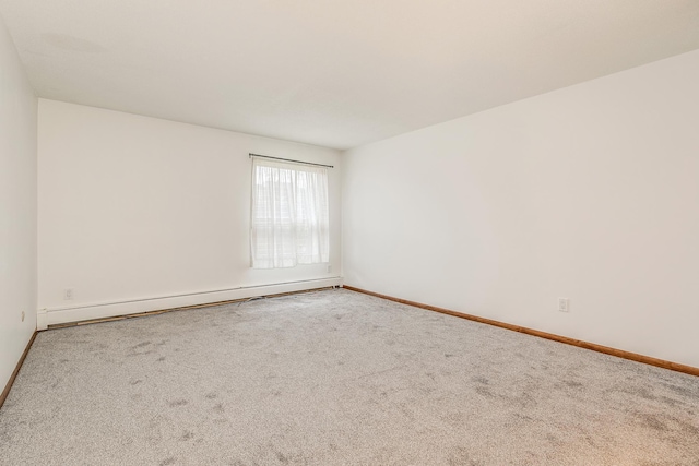 empty room featuring baseboard heating and carpet