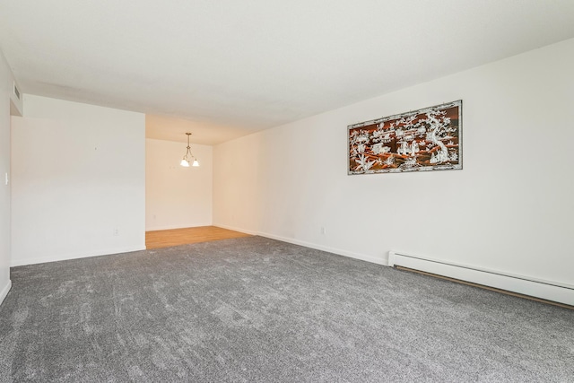 spare room with a chandelier, a baseboard radiator, and carpet floors