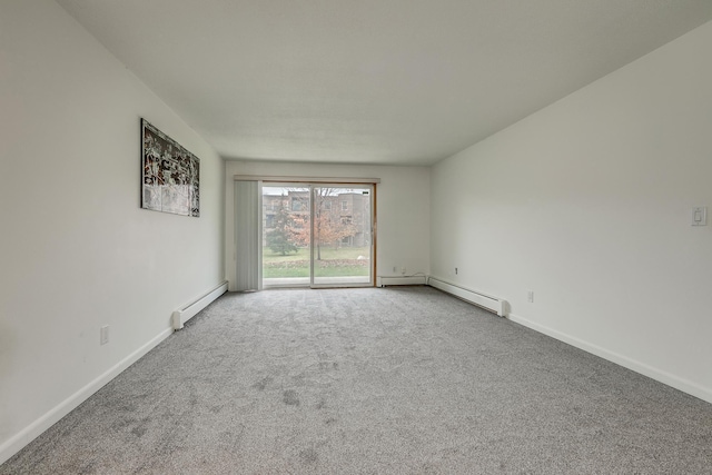 spare room featuring baseboard heating and carpet