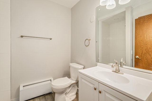 bathroom featuring baseboard heating, wood-type flooring, toilet, and vanity