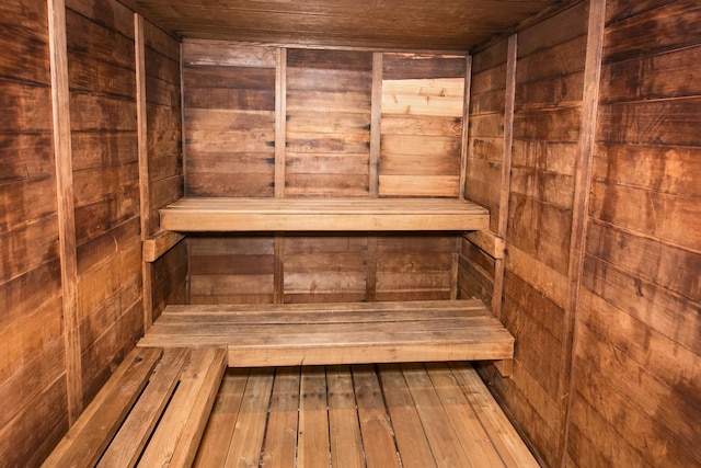 view of sauna with hardwood / wood-style flooring, wooden walls, and wood ceiling