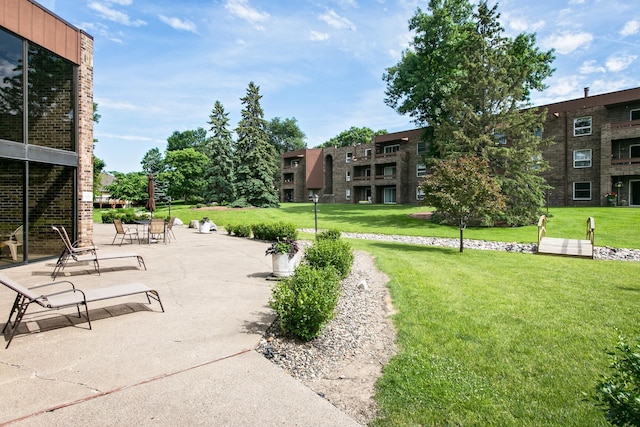 view of community featuring a yard and a patio area