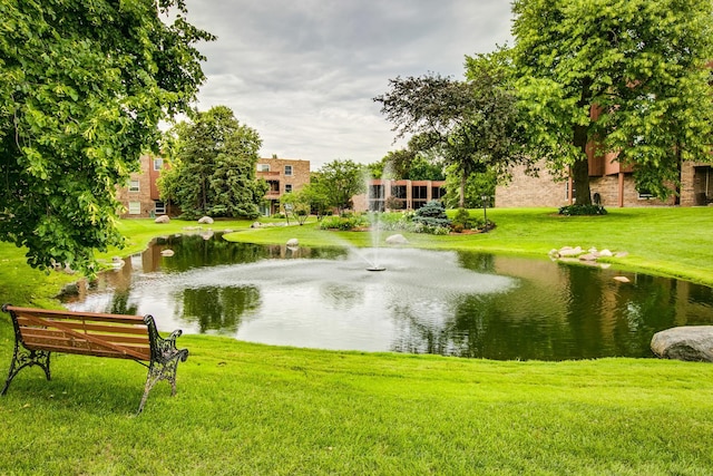 view of home's community with a lawn and a water view