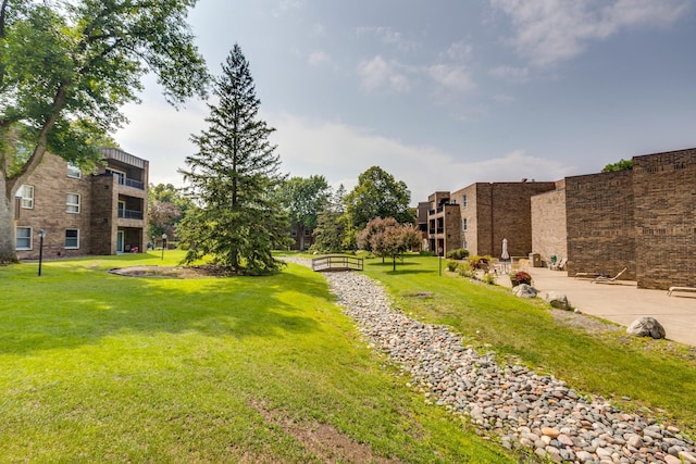 view of home's community with a yard and a patio area