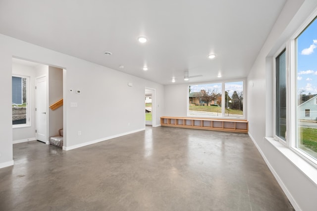 711 7th Ave, Grand Rapids, MN 55744 - unfurnished living room featuring finished concrete flooring, stairs, a ceiling fan, and recessed lighting