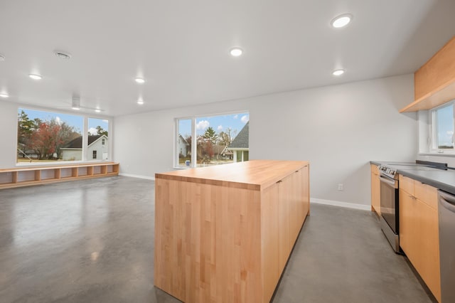 kitchen with wood counters, plenty of natural light, concrete flooring, and light brown cabinetry