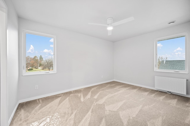 711 7th Ave, Grand Rapids, MN 55744 - unfurnished room with radiator, carpet floors, and a ceiling fan