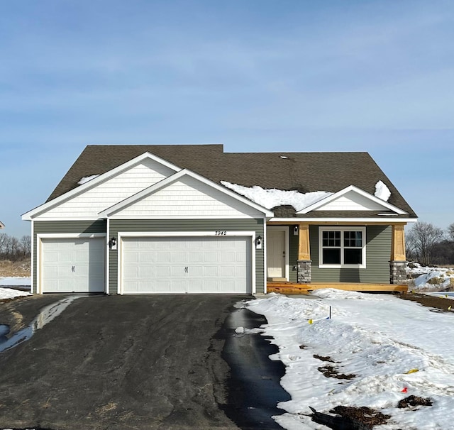 view of front facade featuring a garage and aphalt driveway