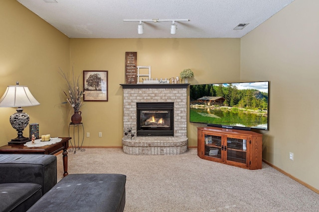 living room featuring baseboards, visible vents, carpet floors, a fireplace, and a textured ceiling