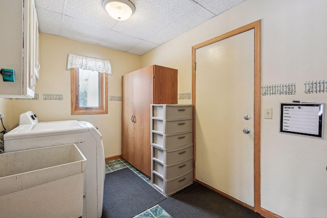 laundry area featuring a sink, washer and dryer, cabinet space, dark colored carpet, and baseboards