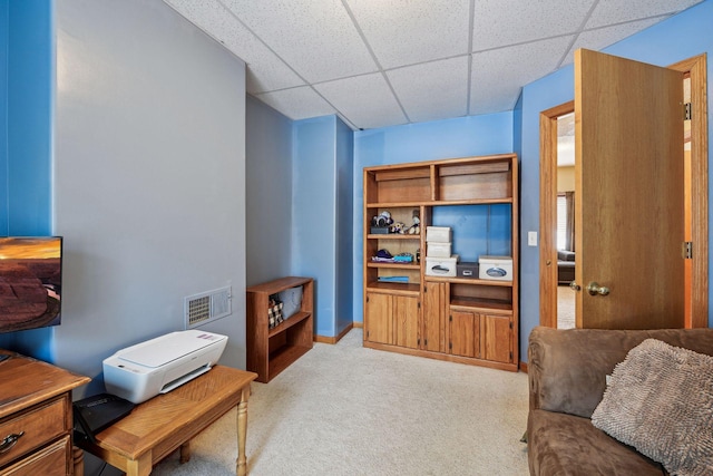 carpeted living area with a paneled ceiling, visible vents, and baseboards