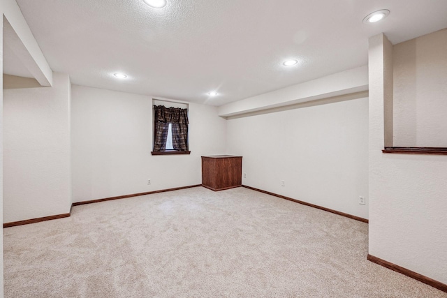 finished below grade area featuring carpet flooring, recessed lighting, baseboards, and a textured ceiling