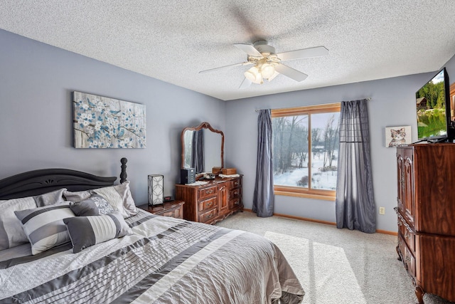 bedroom featuring baseboards, light colored carpet, a ceiling fan, and a textured ceiling