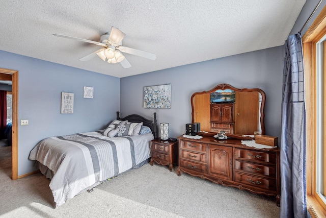 bedroom with a textured ceiling, a ceiling fan, and carpet