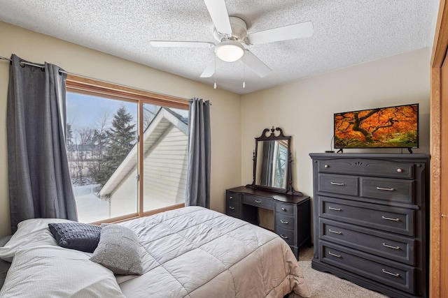 bedroom with a ceiling fan, carpet, and a textured ceiling