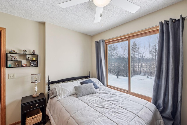 bedroom featuring multiple windows, a textured ceiling, ceiling fan, and access to outside