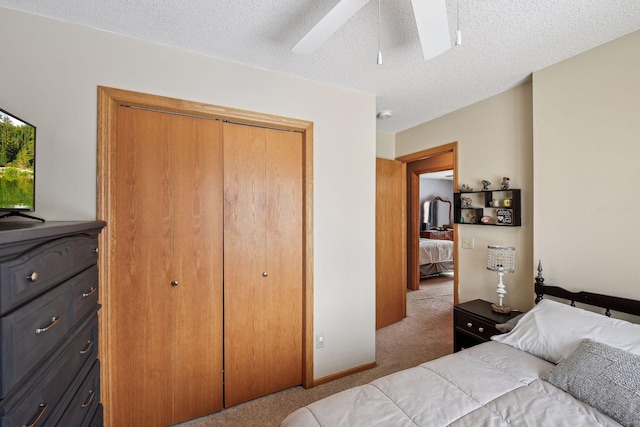 bedroom with ceiling fan, a closet, carpet floors, and a textured ceiling