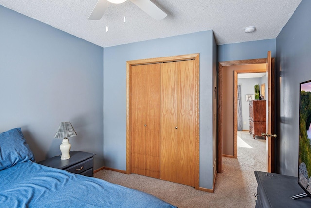 carpeted bedroom featuring a closet, baseboards, a textured ceiling, and ceiling fan