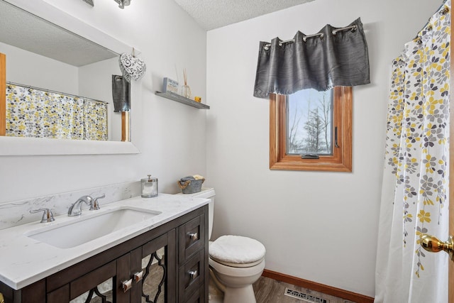 full bathroom with visible vents, baseboards, toilet, vanity, and a textured ceiling