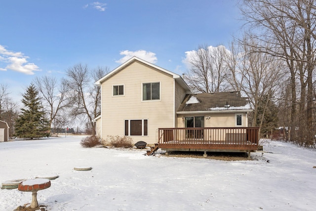 snow covered house with a wooden deck