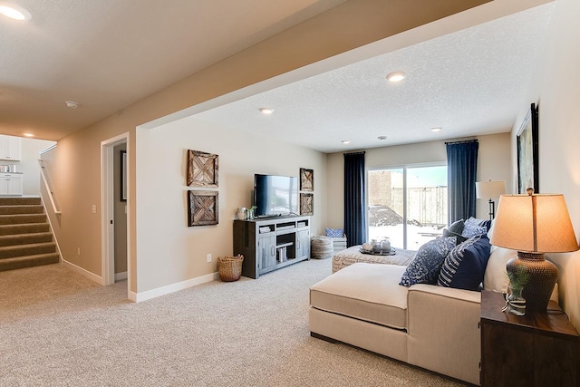 living room featuring a textured ceiling, recessed lighting, carpet floors, baseboards, and stairway