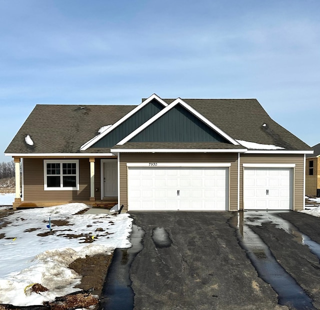 view of front of home with aphalt driveway, an attached garage, and a shingled roof