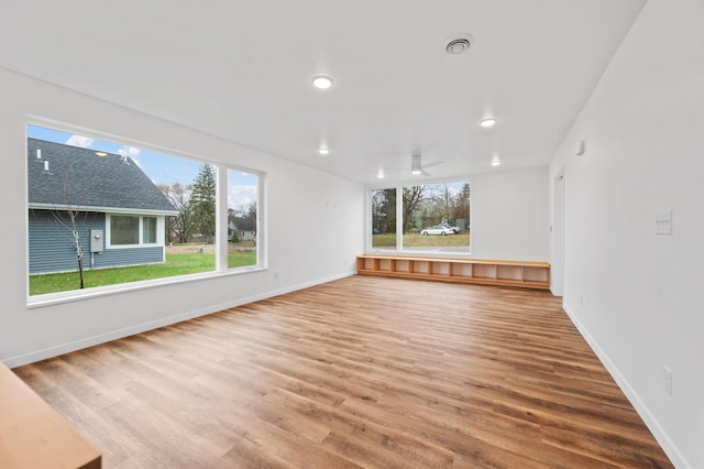 unfurnished living room featuring ceiling fan and hardwood / wood-style flooring