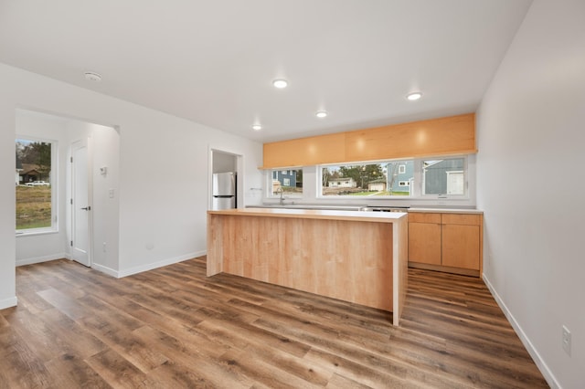 712 8th Ave, Grand Rapids, MN 55744 - kitchen featuring freestanding refrigerator, healthy amount of natural light, dark wood-style flooring, a center island, and recessed lighting
