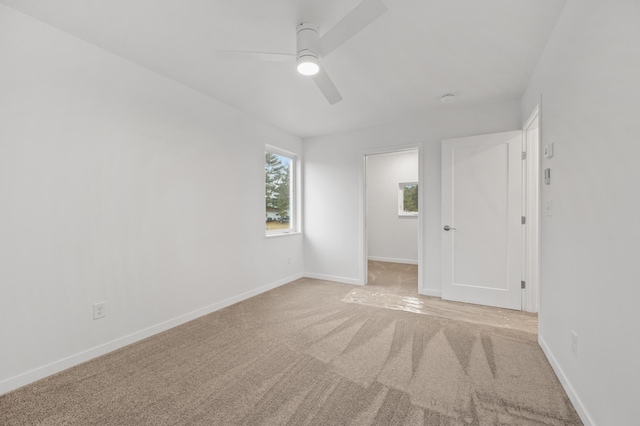 empty room with light colored carpet and ceiling fan