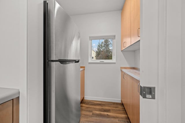 kitchen with stainless steel refrigerator, dark hardwood / wood-style flooring, and light brown cabinets