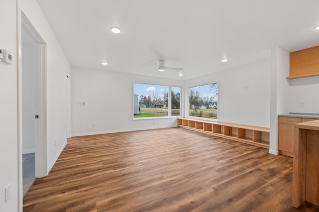 unfurnished living room featuring dark hardwood / wood-style floors and ceiling fan